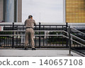 An elderly Japanese man gazes at the townscape along the river. 140657108