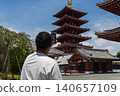 A man taking a photo of a five-story pagoda with his smartphone. 140657109