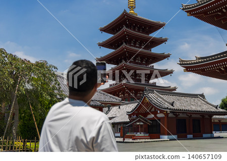 一名男子用智慧型手機拍攝一座五層寶塔。 一名男子用智慧型手機拍攝一座五層寶塔。 140657109