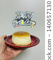 一隻手拿著一個迷你蛋糕，慶祝我最喜歡的偶像的生日。 140657130