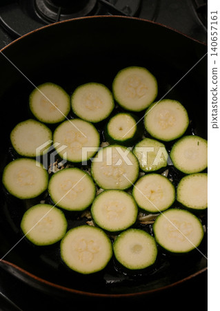 Zucchini being roasted in a frying pan Zucchini being roasted in a frying pan 140657161