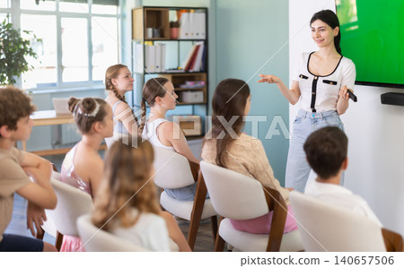 Young woman speaks to audience of teens and preteens listeners Young woman speaks to audience of teens and preteens listeners 140657506