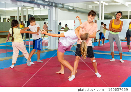 Boys and girls learn together in self-defense lesson to do painful head grab 140657669