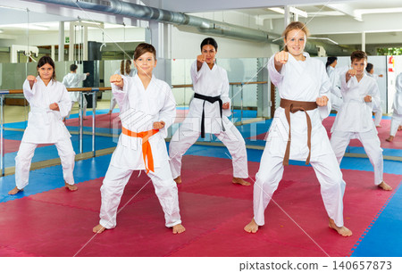 Female trainer is training teenagers in karate class Female trainer is training teenagers in karate class 140657873