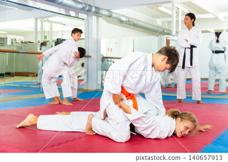 Kids performing arm lock movement during karate training Kids performing arm lock movement during karate training 140657913