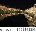 Cherry blossoms at night reflected on the water's surface along the path beside the western moat of Hirosaki Castle. 140658336