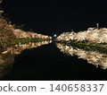 Cherry blossoms at night reflected in the western moat of Hirosaki Castle, as seen from Shunyo Bridge. 140658337