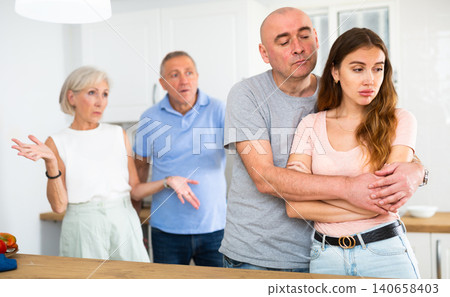 Portrait of an offended couple, which mature family members reprimand Portrait of an offended couple, which mature family members reprimand 140658403