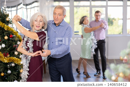 Happy adult man and woman performing ballroom dance in dancing room during celebration Christmas and New Year 140658412