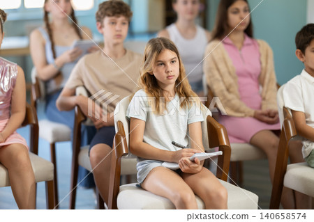 During lecture meeting at class, teens and preteens pupil listen to female teacher During lecture meeting at class, teens and preteens pupil listen to female teacher 140658574