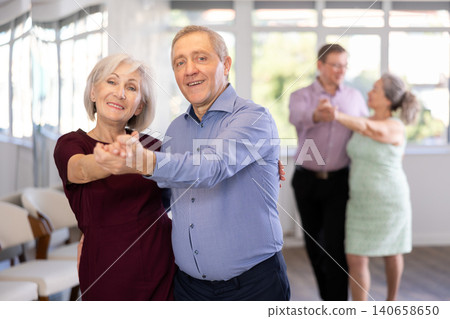 Senior man and elderly woman are dancing classic version of waltz in couple Senior man and elderly woman are dancing classic version of waltz in couple 140658650