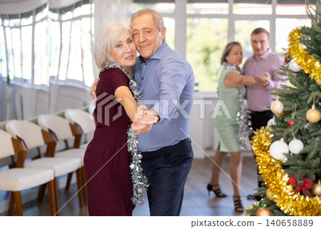 In studio decorated for New Year, elderly man and woman perky dance pair discofox. In studio decorated for New Year, elderly man and woman perky dance pair discofox. 140658889