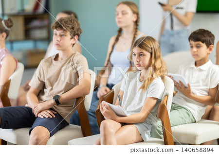 Children and teenagers listening to teacher in classroom Children and teenagers listening to teacher in classroom 140658894