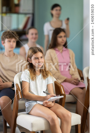 During lecture meeting at class, teens and preteens pupil listen to female teacher During lecture meeting at class, teens and preteens pupil listen to female teacher 140659030