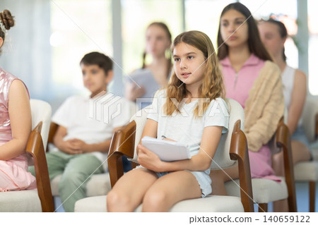 Children and teenagers listening to teacher in classroom Children and teenagers listening to teacher in classroom 140659122