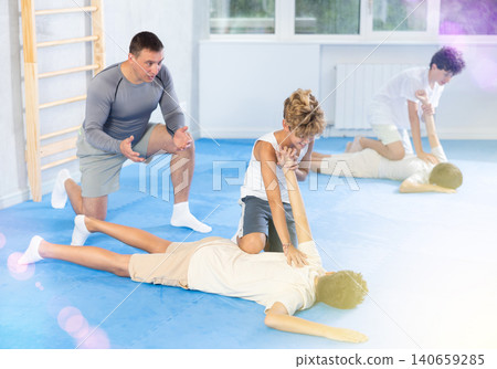 Diligent preteen student twisting his opponent's arm on the floor Diligent preteen student twisting his opponent's arm on the floor 140659285