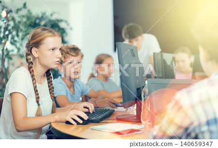 Portrait of female schoolgirl at computers in computer class Portrait of female schoolgirl at computers in computer class 140659347
