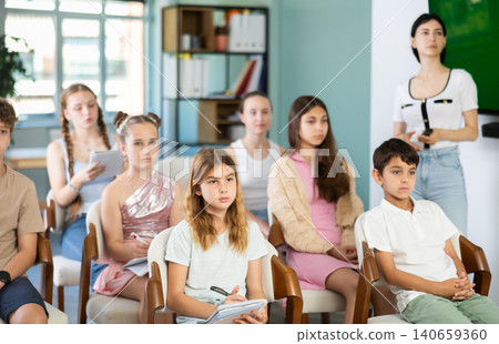 Children and teenagers listening to teacher in classroom Children and teenagers listening to teacher in classroom 140659360