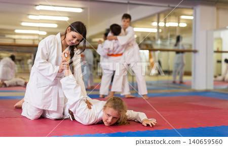 Young girls and boys exercising karate movements Young girls and boys exercising karate movements 140659560