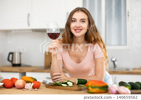 Housewife preparing vegetable salad and drinking red wine Housewife preparing vegetable salad and drinking red wine 140659562