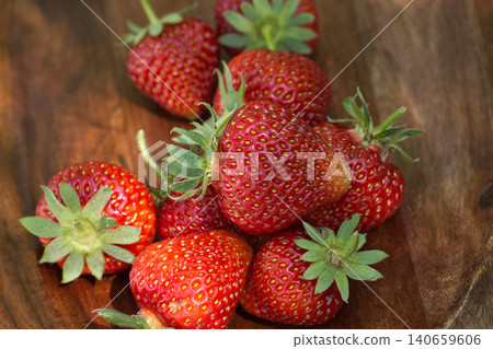 Fresh ripe strawberries piled in a rustic wooden bowl with natural lighting Fresh ripe strawberries piled in a rustic wooden bowl with natural lighting 140659606