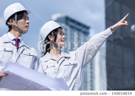 A man and a woman in work clothes having a meeting 140659659