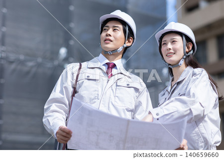 A man and a woman in work clothes having a meeting 140659660
