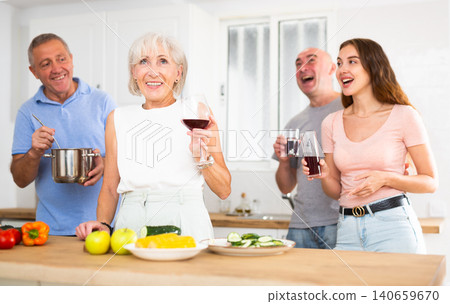 Happy family with elderly parents preparing lunch in modern kitchen Happy family with elderly parents preparing lunch in modern kitchen 140659670