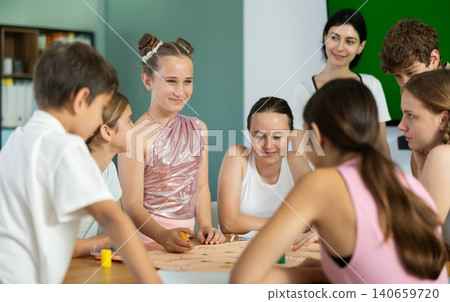 Group of children and teens playing board game. Group of children and teens playing board game. 140659720