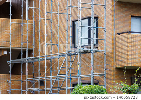 Scaffolding installed to repair the exterior wall of an apartment building Scaffolding installed to repair the exterior wall of an apartment building 140659728