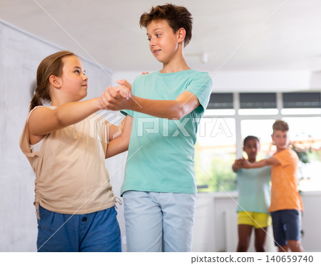 Portrait of girl with boy performing pair dance movements Portrait of girl with boy performing pair dance movements 140659740