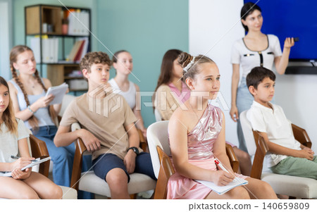 Children and teenagers listening to teacher in classroom Children and teenagers listening to teacher in classroom 140659809