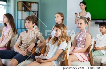Children and teenagers listening to teacher in classroom Children and teenagers listening to teacher in classroom 140659846