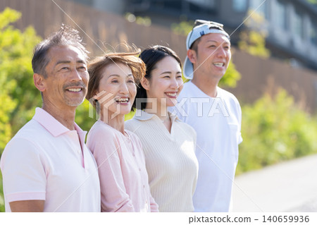 A senior couple and a young couple standing side by side, both smiling. A senior couple and a young couple standing side by side, both smiling. 140659936