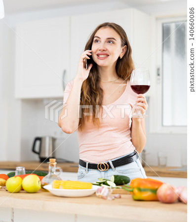 Positive young woman communicates with someone on a mobile phone Positive young woman communicates with someone on a mobile phone 140660086