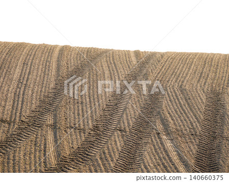 A landscape with tractor tire tracks remaining in a tilled field. A landscape with tractor tire tracks remaining in a tilled field. 140660375