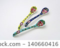 A white background with colorful Peranakan ceramic teaspoons. 140660416