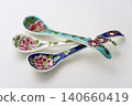 A white background with colorful Peranakan ceramic teaspoons. 140660419
