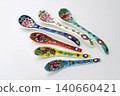 A white background with colorful Peranakan ceramic teaspoons. 140660421