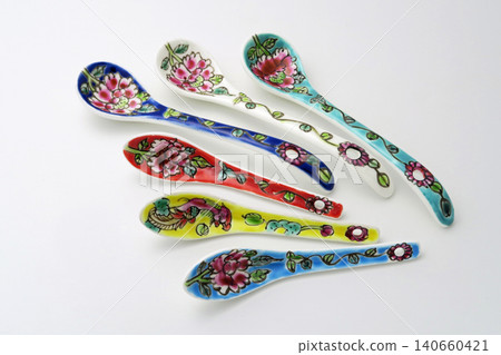 A white background with colorful Peranakan ceramic teaspoons. A white background with colorful Peranakan ceramic teaspoons. 140660421