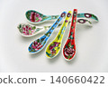 A white background with colorful Peranakan ceramic teaspoons. 140660422