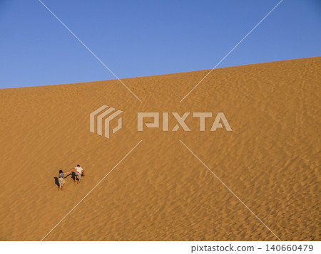 Walking across the Tottori Sand Dunes in the morning light Walking across the Tottori Sand Dunes in the morning light 140660479