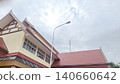 Modern Thai-style architecture building with tiled roof under a cloudy sky background photography 140660642