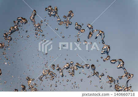 Splashes and jets of water against light background. Splashes and jets of water against light background. 140660718