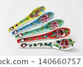 A white background with colorful Peranakan ceramic teaspoons. 140660757