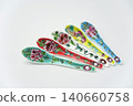 A white background with colorful Peranakan ceramic teaspoons. 140660758