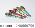 A white background with colorful Peranakan ceramic teaspoons. 140660759