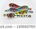 A white background with colorful Peranakan ceramic teaspoons. 140660760
