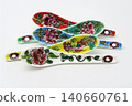 A white background with colorful Peranakan ceramic teaspoons. 140660761