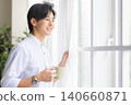 A man looking out the window 140660871